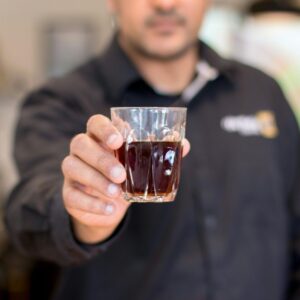 Selective Focus Photo of Man's Hand Holding Drinking Glass With Liquid Inside