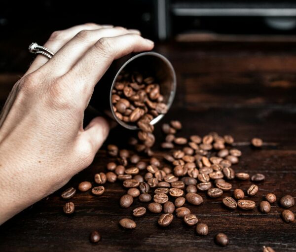 Woman pouring coffee beans on table